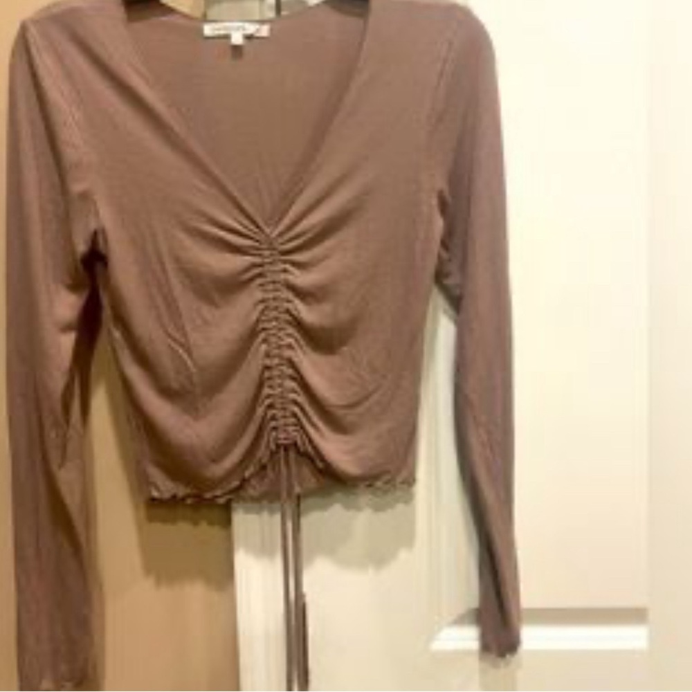 A cute beige crop top with draw strings to adjust level of crop-ness.